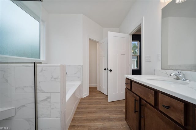 bathroom featuring a washtub, wood-type flooring, and vanity