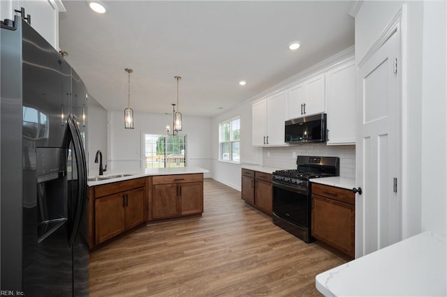 kitchen featuring hardwood / wood-style flooring, black gas stove, sink, and fridge with ice dispenser