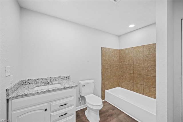 full bathroom with wood-type flooring, tiled shower / bath combo, toilet, and vanity