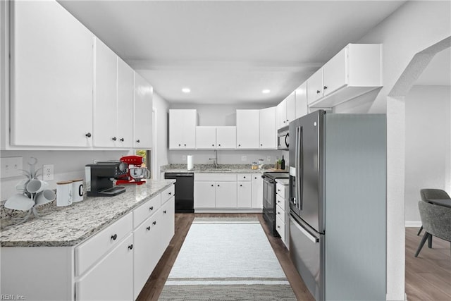 kitchen featuring white cabinetry, black appliances, dark hardwood / wood-style floors, and sink