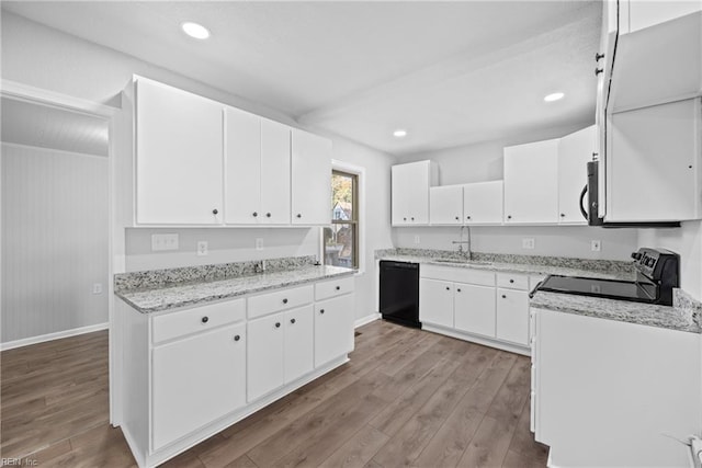 kitchen with black appliances, white cabinetry, and light hardwood / wood-style flooring