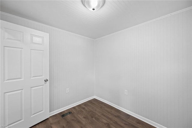 unfurnished room with dark wood-type flooring and crown molding