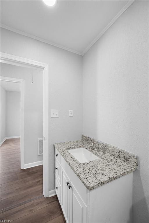 bathroom featuring vanity, wood-type flooring, and crown molding