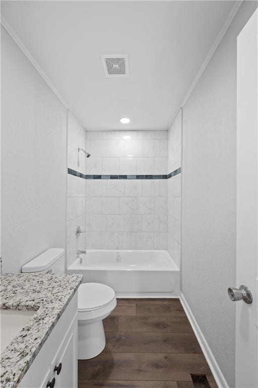 full bathroom with wood-type flooring, vanity, crown molding, toilet, and tiled shower / bath combo