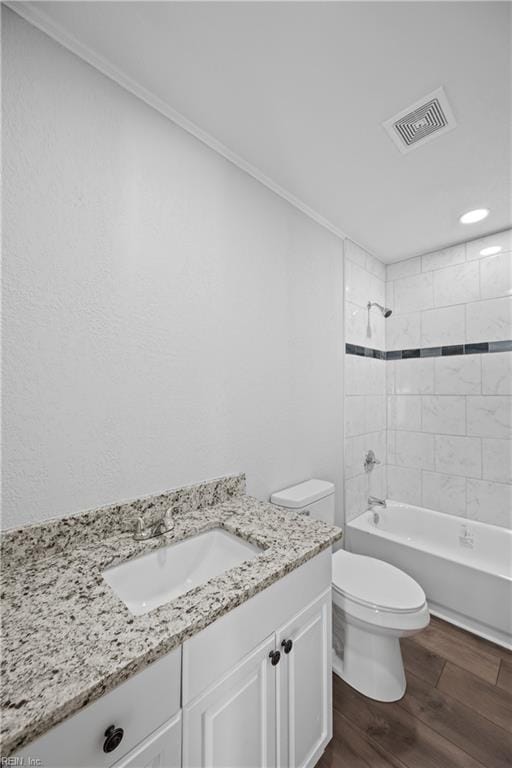 full bathroom featuring hardwood / wood-style floors, vanity, toilet, and tiled shower / bath