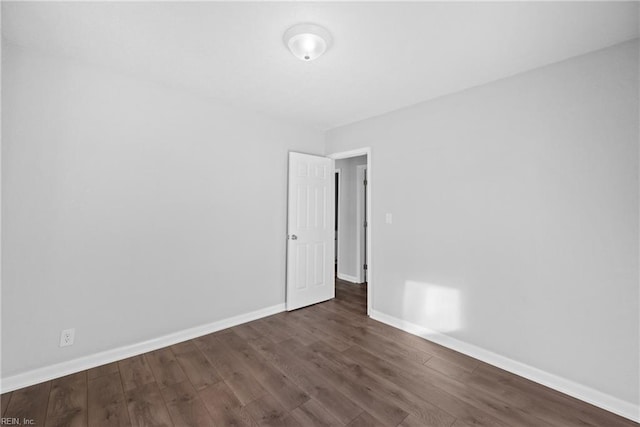 unfurnished room with dark hardwood / wood-style flooring