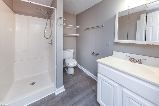 bathroom featuring a textured ceiling, wood-type flooring, vanity, a shower, and toilet