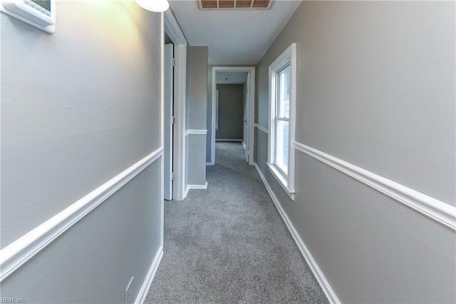 corridor with carpet and a healthy amount of sunlight