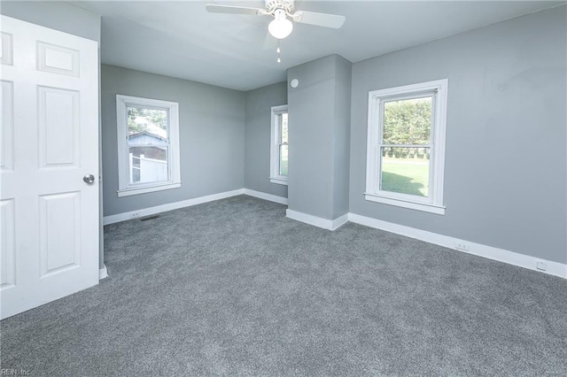 carpeted spare room with a wealth of natural light and ceiling fan