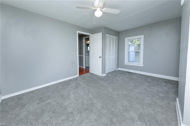 unfurnished bedroom featuring dark colored carpet, ceiling fan, and a closet