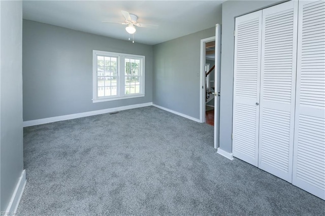 unfurnished bedroom with carpet, ceiling fan, and a closet