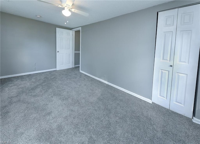 unfurnished room featuring dark carpet and ceiling fan