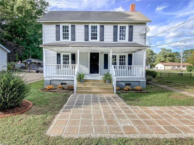 colonial-style house with a front yard and a porch