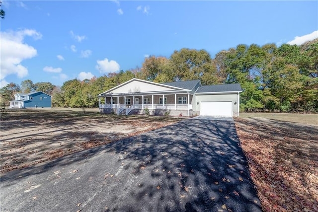 ranch-style home featuring a garage and covered porch