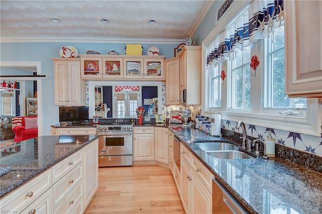 kitchen featuring high end stove, sink, a healthy amount of sunlight, and crown molding