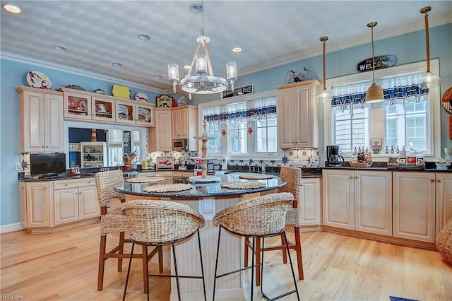 kitchen with hanging light fixtures, light wood-type flooring, and a center island