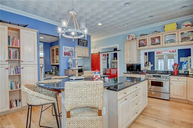 kitchen featuring stainless steel appliances, a kitchen bar, dark stone countertops, and light hardwood / wood-style flooring