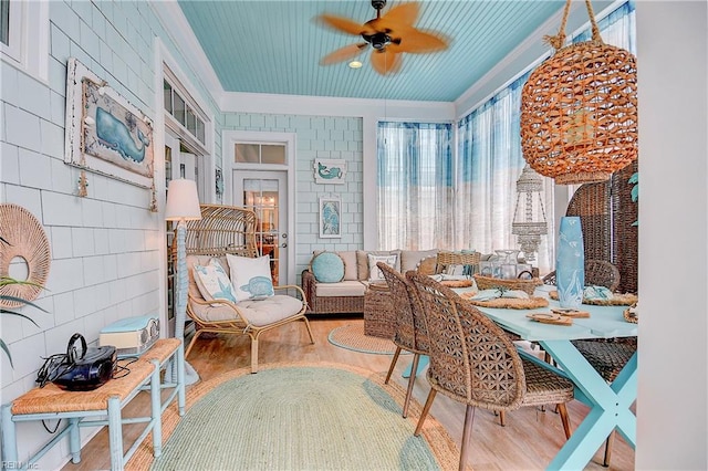 sitting room featuring wood-type flooring, ceiling fan, and crown molding