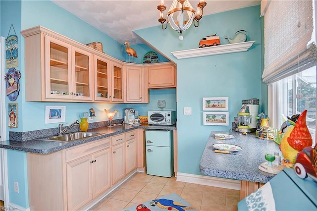 kitchen featuring sink, a chandelier, light tile patterned floors, light brown cabinets, and decorative light fixtures