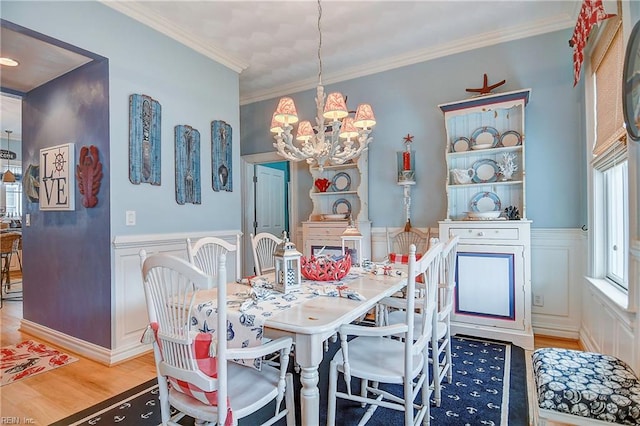 dining room featuring hardwood / wood-style flooring, a notable chandelier, and ornamental molding