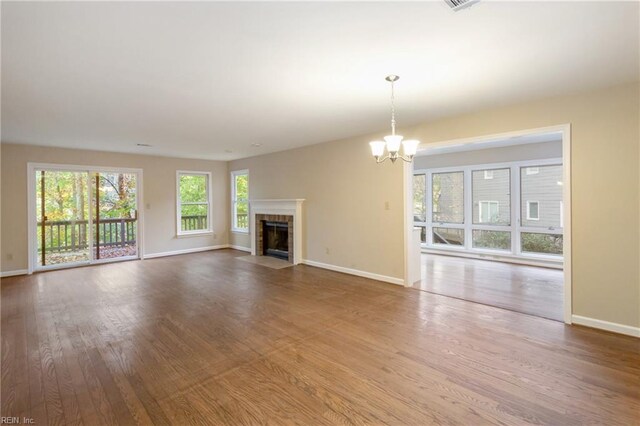 unfurnished living room with wood-type flooring and a notable chandelier