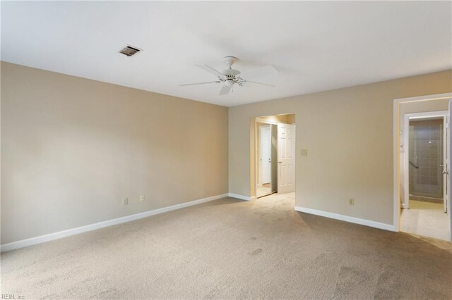 spare room with ceiling fan and light carpet