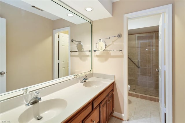 bathroom featuring vanity, tile patterned floors, toilet, and a tile shower