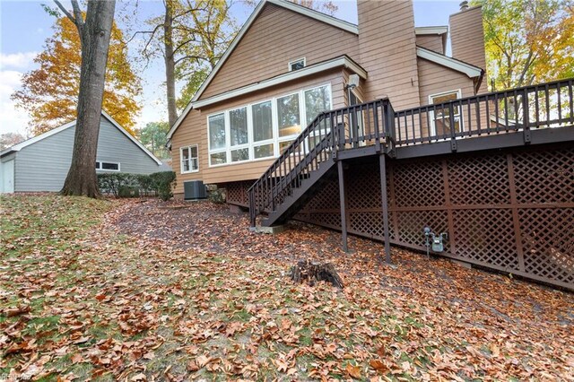 rear view of house featuring central AC unit and a wooden deck