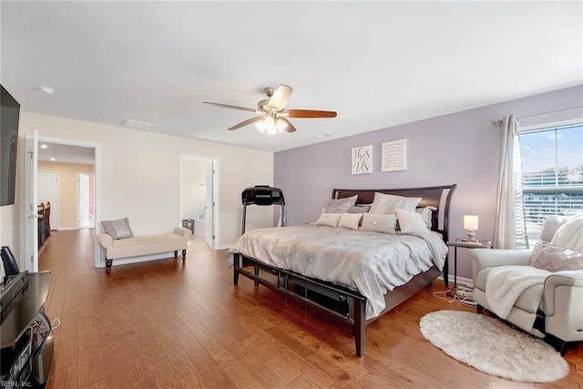 bedroom featuring connected bathroom, hardwood / wood-style floors, and ceiling fan