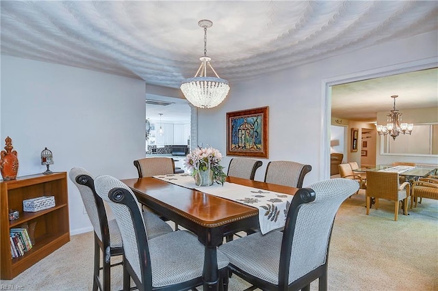 carpeted dining area featuring a chandelier