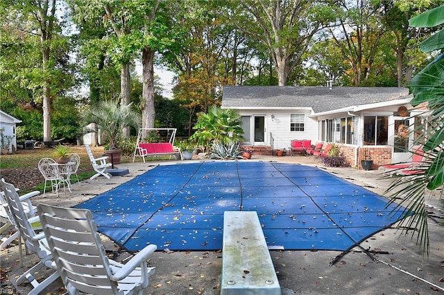 view of pool featuring a diving board and a patio