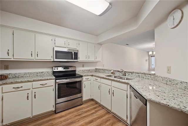 kitchen with white cabinetry, light wood-type flooring, appliances with stainless steel finishes, and sink