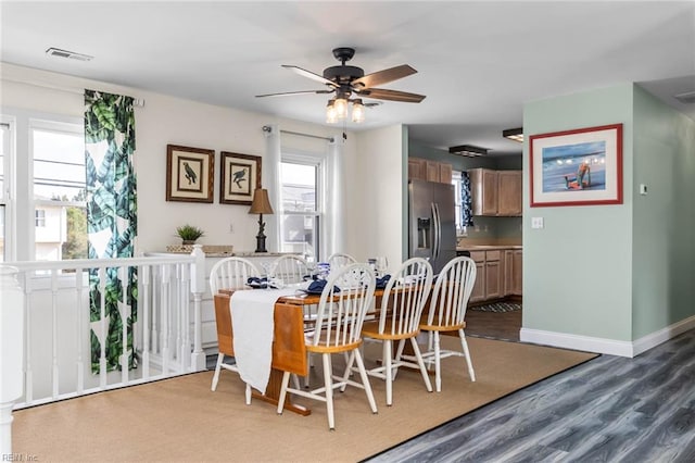 dining area with ceiling fan and dark hardwood / wood-style flooring