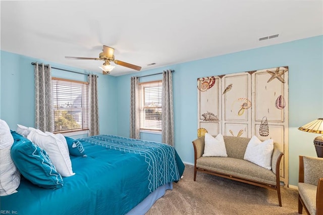 carpeted bedroom with multiple windows and ceiling fan