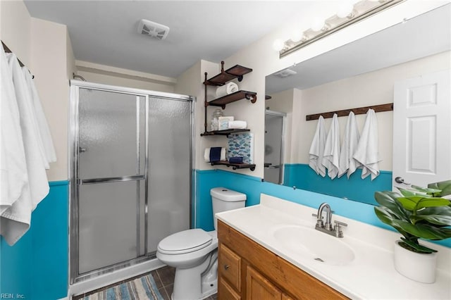 bathroom with vanity, tile patterned floors, toilet, and a shower with shower door