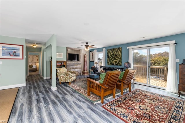 living room featuring ceiling fan and dark hardwood / wood-style floors