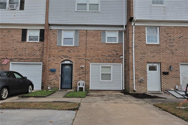 townhome / multi-family property featuring a garage and cooling unit