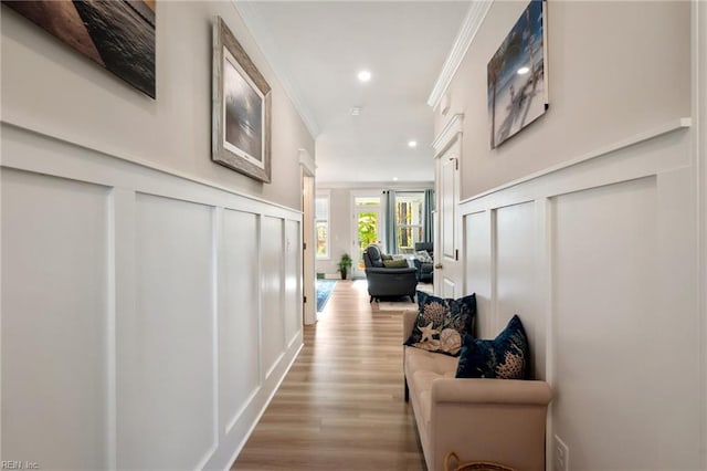 hall with crown molding and light hardwood / wood-style flooring