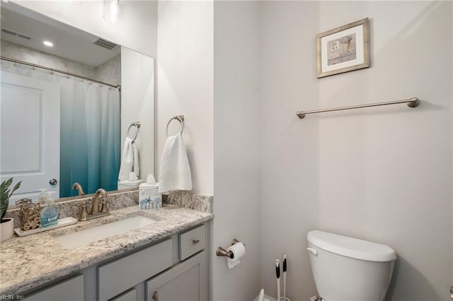 bathroom featuring toilet, vanity, and a shower with shower curtain