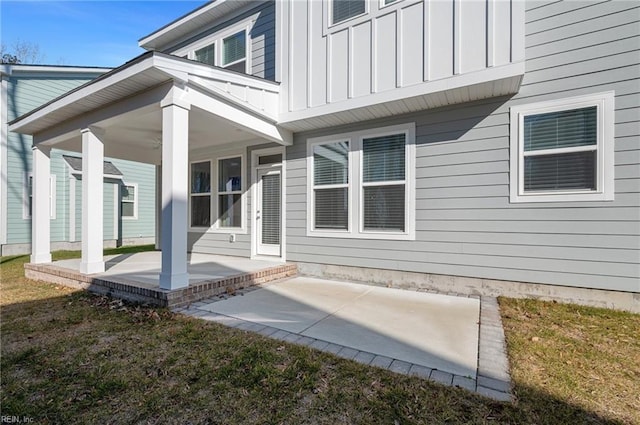 entrance to property featuring a yard and a patio