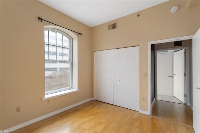 unfurnished bedroom with a closet and light hardwood / wood-style flooring