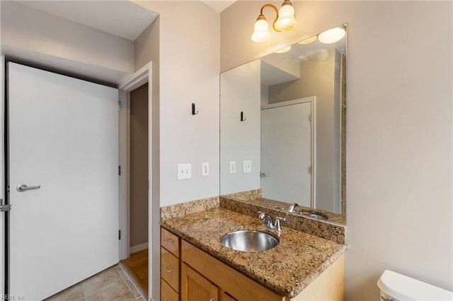 bathroom with toilet, tile patterned flooring, and vanity