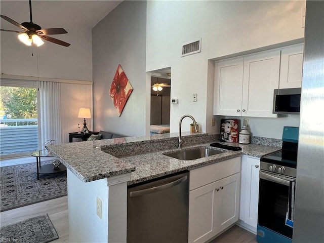 kitchen featuring sink, white cabinetry, kitchen peninsula, and appliances with stainless steel finishes