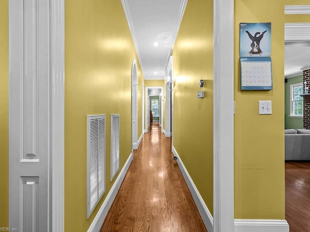 hall with hardwood / wood-style floors and crown molding