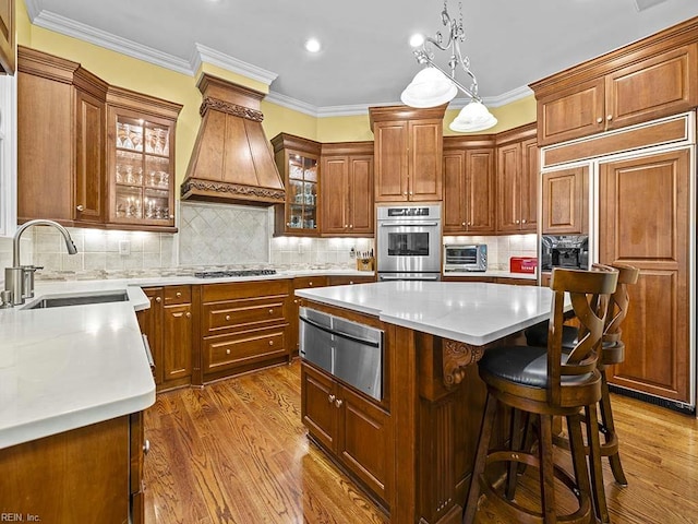 kitchen featuring appliances with stainless steel finishes, dark hardwood / wood-style flooring, premium range hood, and a kitchen island