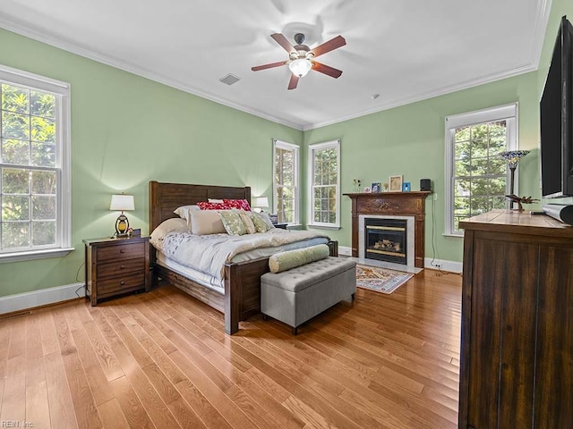 bedroom featuring ornamental molding, light hardwood / wood-style floors, and ceiling fan