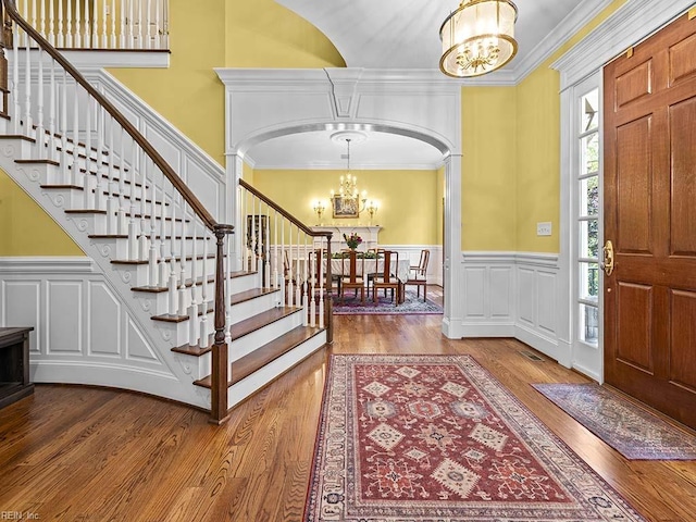 entryway featuring hardwood / wood-style floors, a chandelier, and crown molding