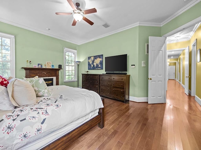 bedroom with hardwood / wood-style flooring, ceiling fan, and multiple windows