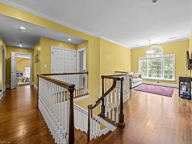 hallway featuring dark hardwood / wood-style floors, an inviting chandelier, and crown molding