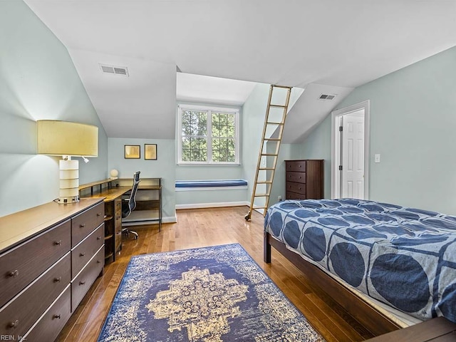 bedroom featuring lofted ceiling, wood-type flooring, and built in desk